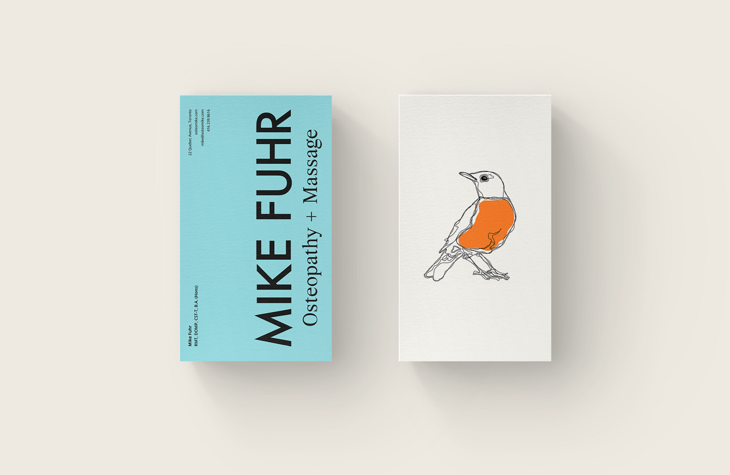 Mike Fuhr Osteopathy and Massage business cards featuring the robin illustration and blue brand colour.
