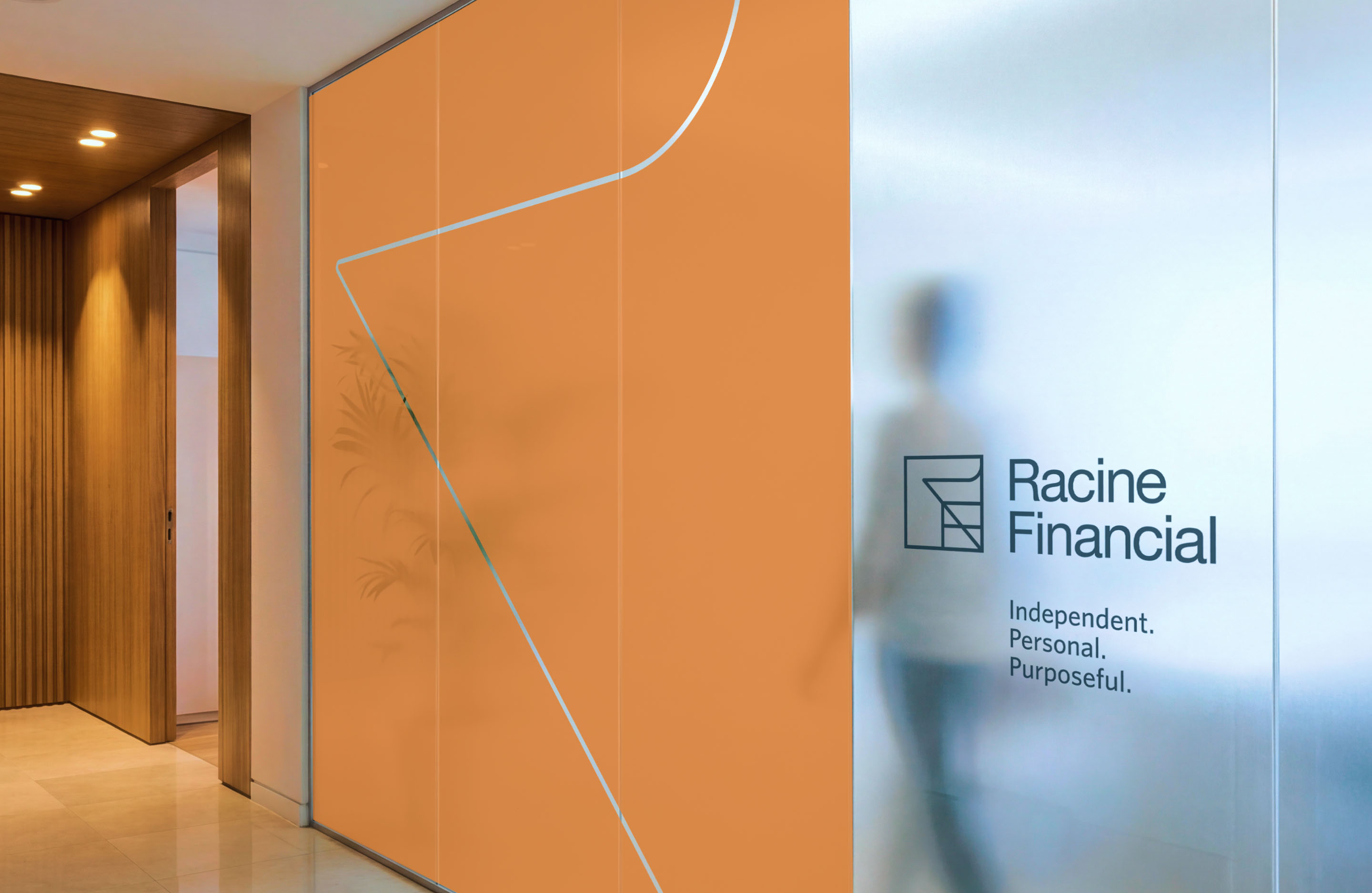 Racine Financial office interior with orange wall graphics and branded glass signage.